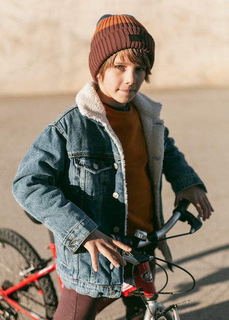 Boy posing outdoors in the city with his bike