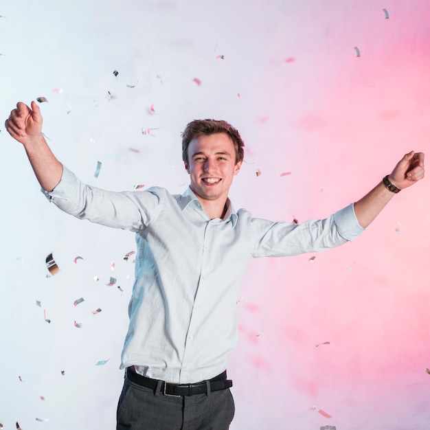 Free photo boy posing with confetti at a new year party