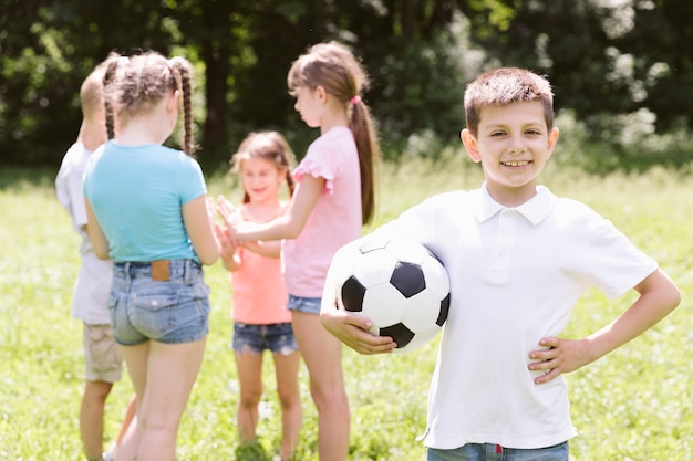 Бесплатное фото Мальчик позирует с футбольным мячом