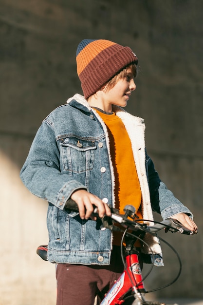 街の屋外で自転車でポーズをとる少年