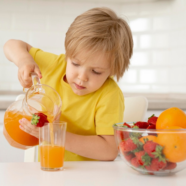 Free photo boy pouring juice