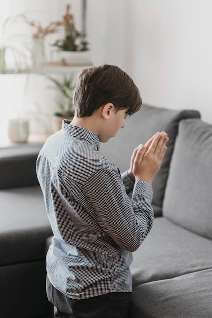 居間で祈る少年