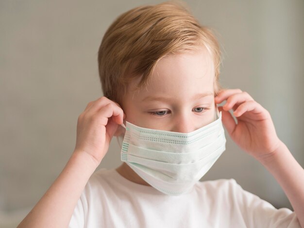 Boy putting on mask