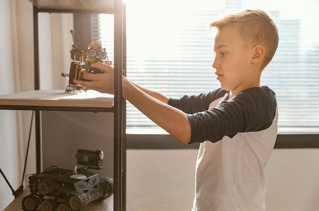 Boy putting on shelf robot