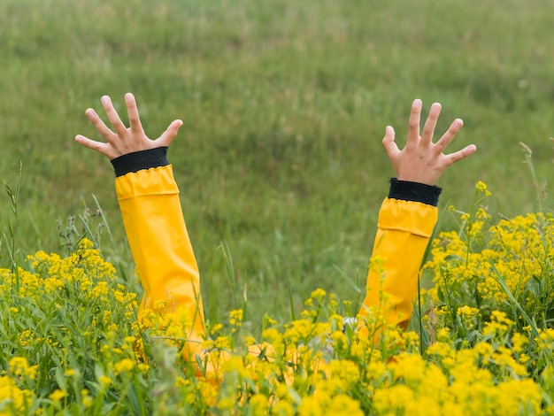 Boy in raincoat hands in the air