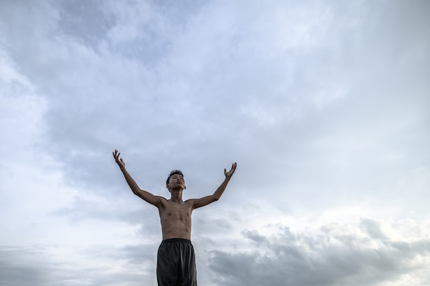 Foto gratuita il ragazzo alzò la mano verso il cielo per chiedere pioggia, riscaldamento globale e crisi idrica