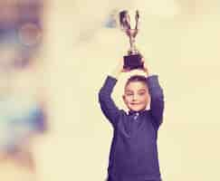 Free photo boy raising his trophy