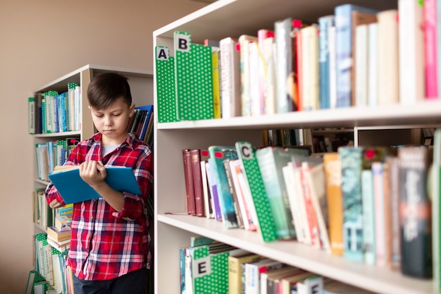 Boy reading between shelves