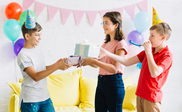 Boy receiving birthday gift from his friends