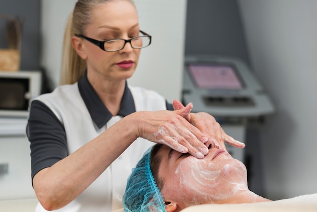 Free photo boy receiving facial treatment in a beauty salon