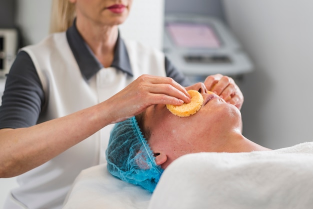 Free photo boy receiving facial treatment in a beauty salon