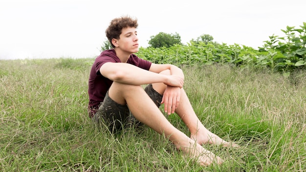 Foto gratuita ragazzo che si distende e che gode della natura