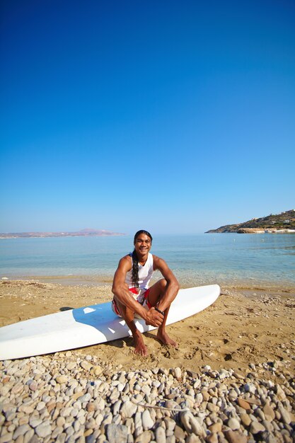 Boy resting on surfboard