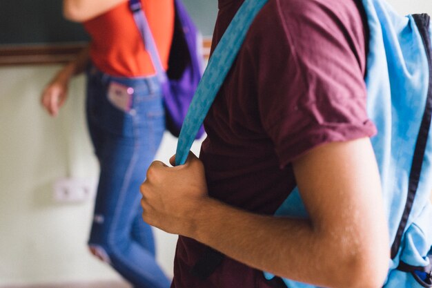 Boy's hands holding backpack