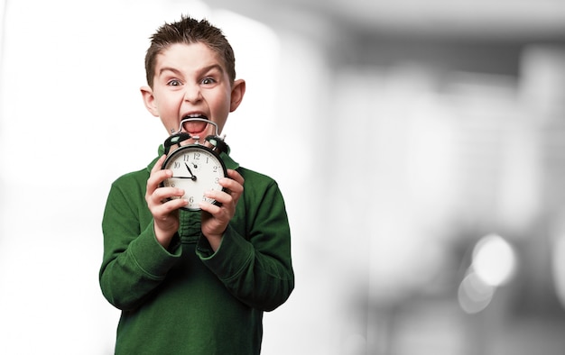 Free photo boy screaming with an alarm clock