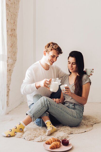 Boy serving milk to his girlfriend