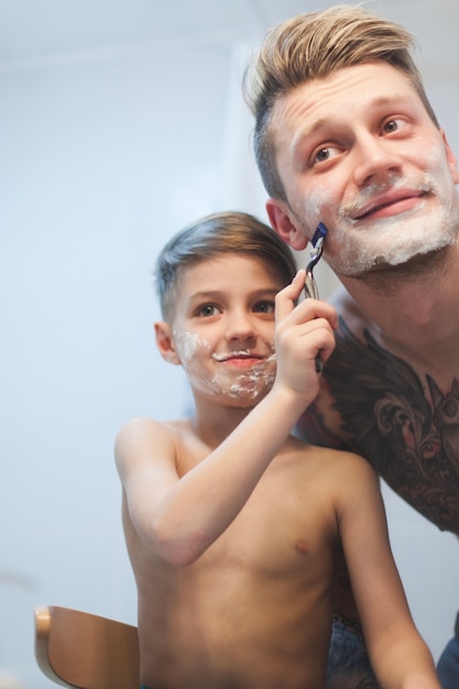 Boy shaving his father