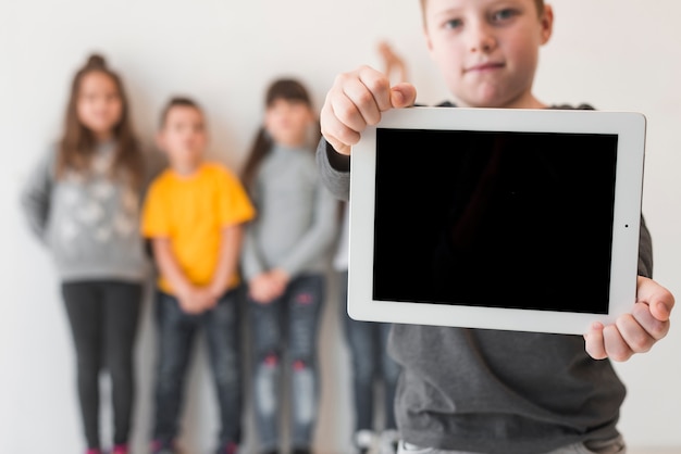 Free photo boy showing tablet