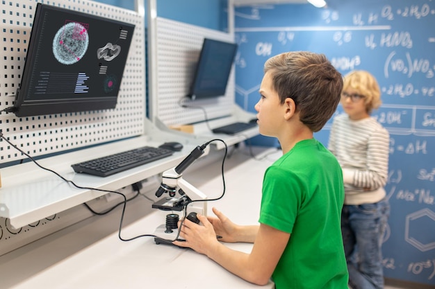 Boy sideways to camera looking intently at charging board