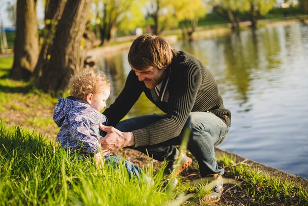 Boy sitting on grass with his father