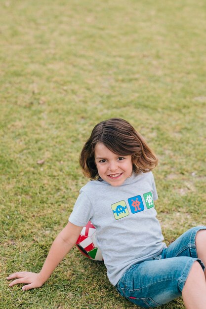 Boy sitting and leaning on football