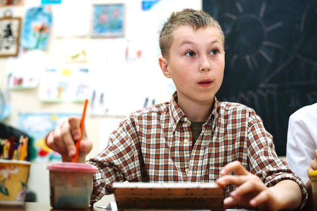 Free photo boy sitting on painting lesson