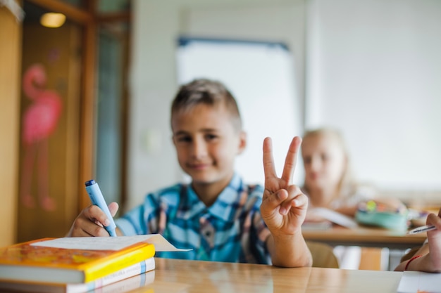 学校の机の身に着けている男の子