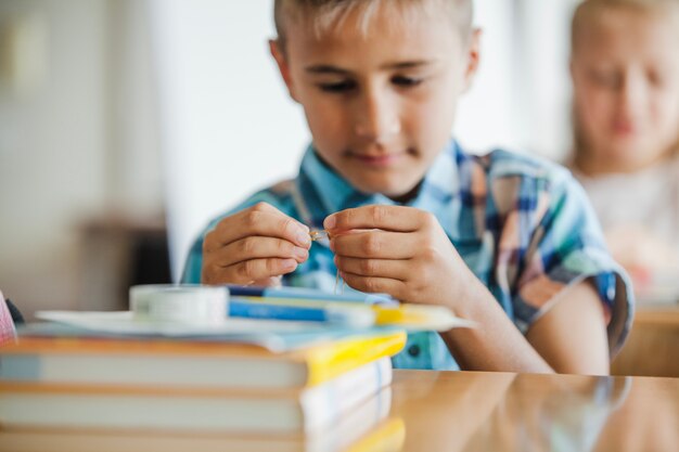 学校のテーブルに座っている男の子