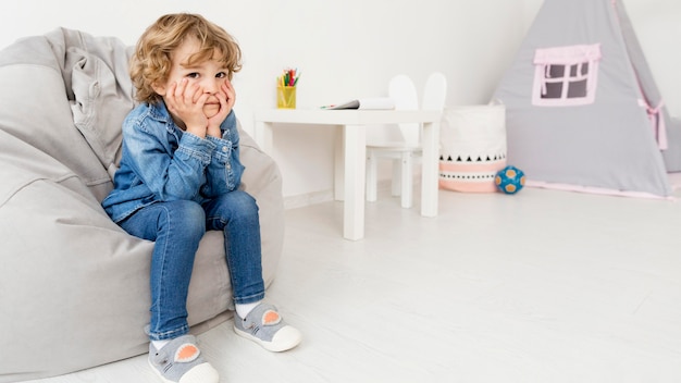 Boy sitting on sofa at home