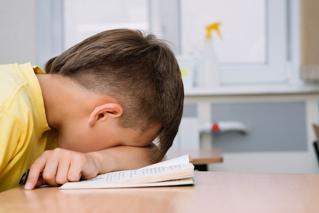 Boy sleeping leaning on table