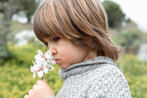 花の匂いを嗅ぐ少年