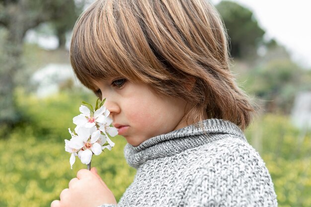 boy smelling flower
