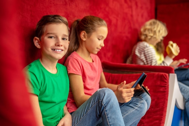 Free photo boy smiling at camera sitting resting with classmates