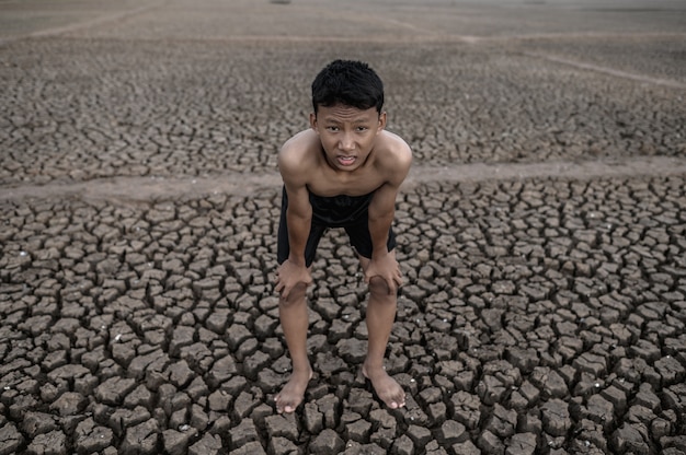 Free photo the boy standing bent over and hand catch knees, global warming and water crisis