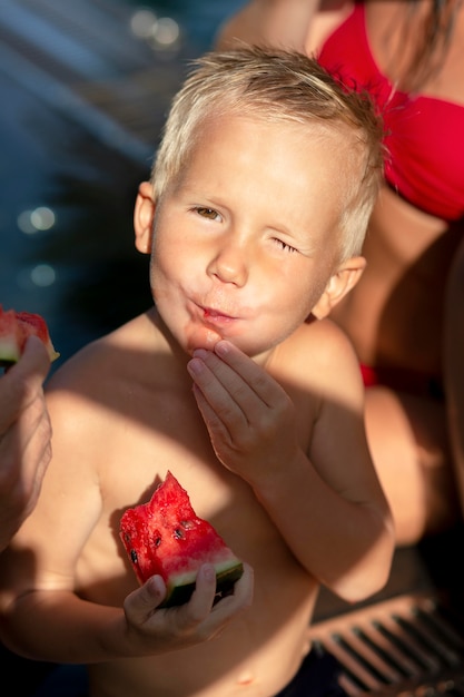 Foto gratuita ragazzo in piscina con l'anguria