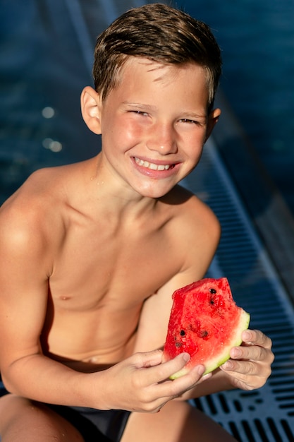 Мальчик у бассейна с арбузом