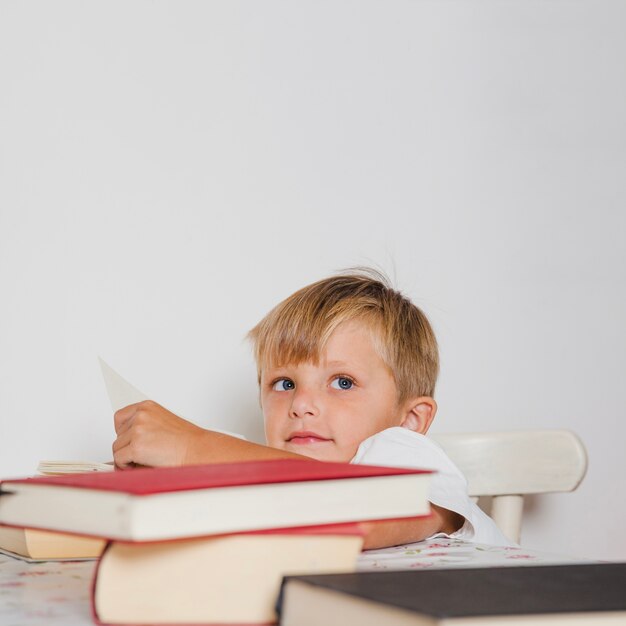 書籍付きのテーブルの少年