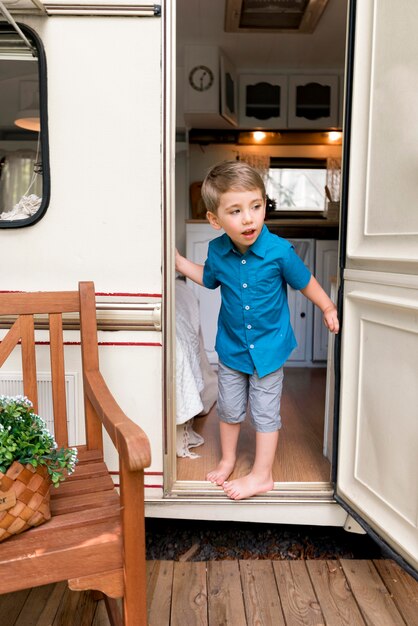 Мальчик заглядывает за дверь своего каравана