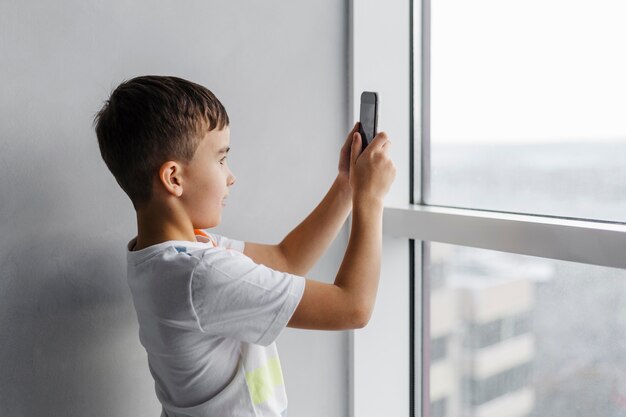 Boy taking pictures with his mobile phone