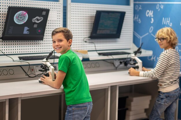 Boy turning to camera standing near charge board