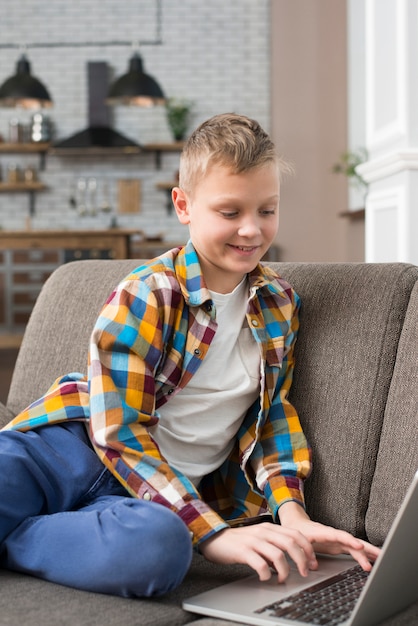 Boy using laptop on couch