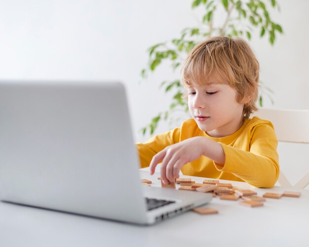 Boy using laptop and toys at home