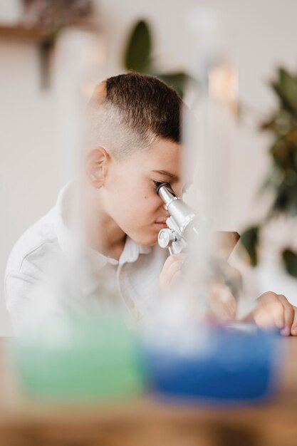 Boy using a microscope to learn science