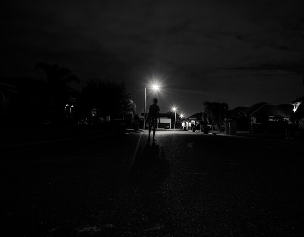 夜の街灯の下で一人歩いている男の子