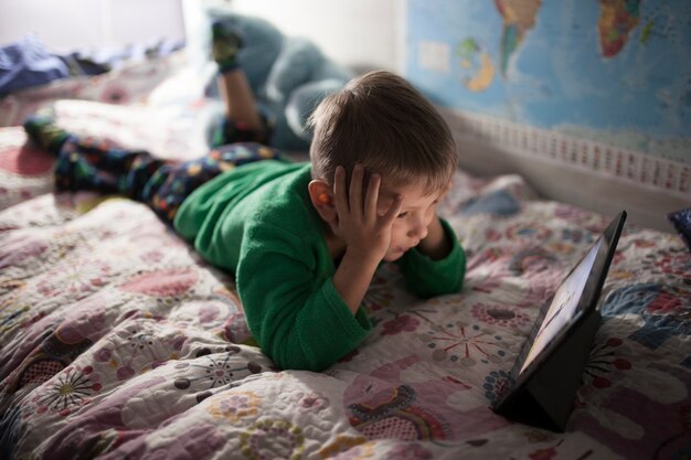 Boy watching movie on bed