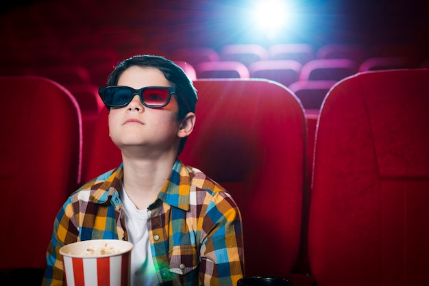 映画館で映画を見ている少年