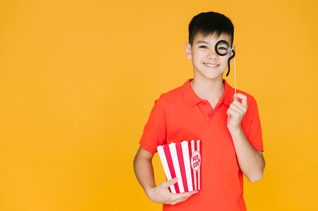 Boy wearing a fake monocle with copy space