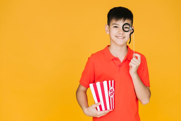 Boy wearing a fake monocle with copy space