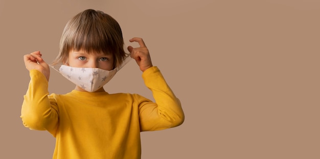 Foto gratuita ragazzo che indossa una maschera medica con copia spazio