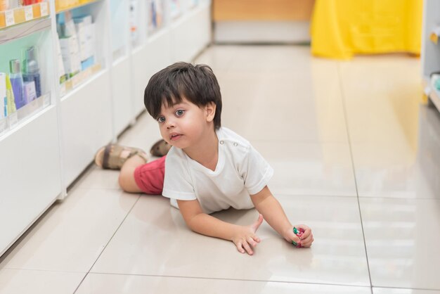 Boy in white tshirt lying on the floor